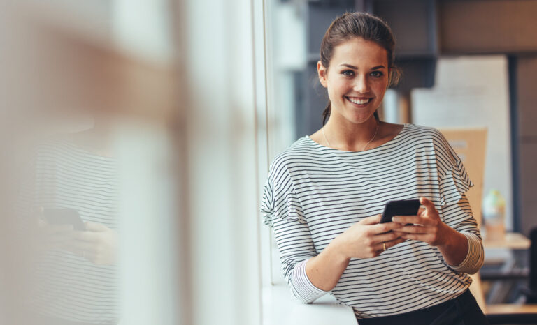 Businesswoman In Office Using A Cell Phone